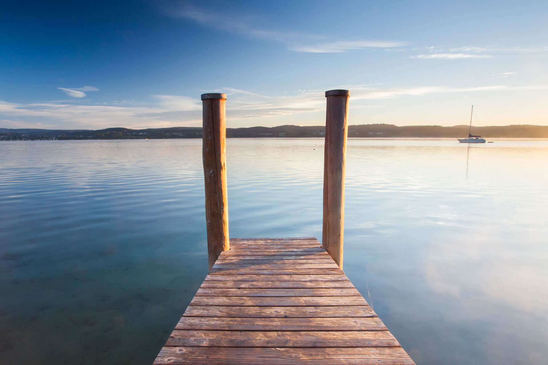 Steg auf der insel reichenau im Bodensee mit segelboot bei sonnenaufgang